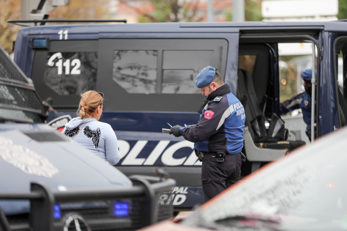 Un agente de la Policía Municipal multa a una mujer por un viaje no justificado en un control policial en la Glorieta del Marqués de Vadillo durante el sexto día de confinamiento por coronavirus en