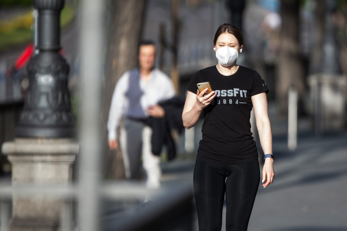 Una mujer con mascarilla hace una foto con el móvil en el segundo día de desconfinamiento durante la Pandemia Covid-19 que ha generado el Estado de Alarma en España. A 3 de Mayo, 2020 en Madrid, Es