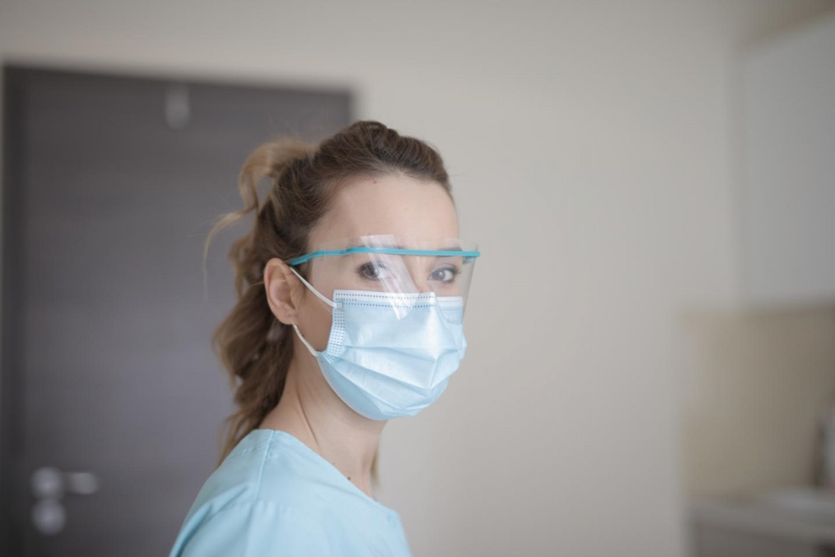 Profesional sanitaria con mascarilla y gafas protectoras.