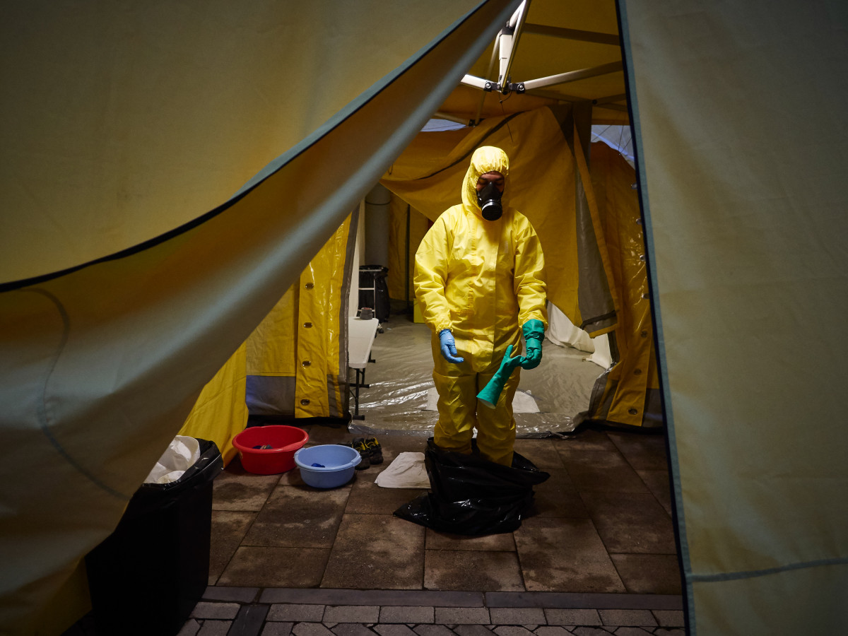 Un voluntario de DYA Navarra se desinfecta y se quita el traje EPI después de la jornada de limpieza y desinfección en el Hospital de Navarra durante la cuarta semana de confinamiento por el Estado 