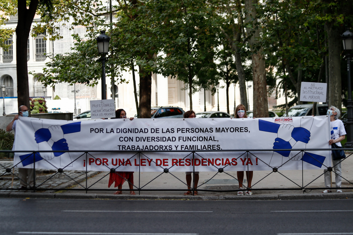 Varias personas sostienen una pancarta durante una concentración convocada por Marea de Residencias para exigir una ley estatal que regule el sector con 