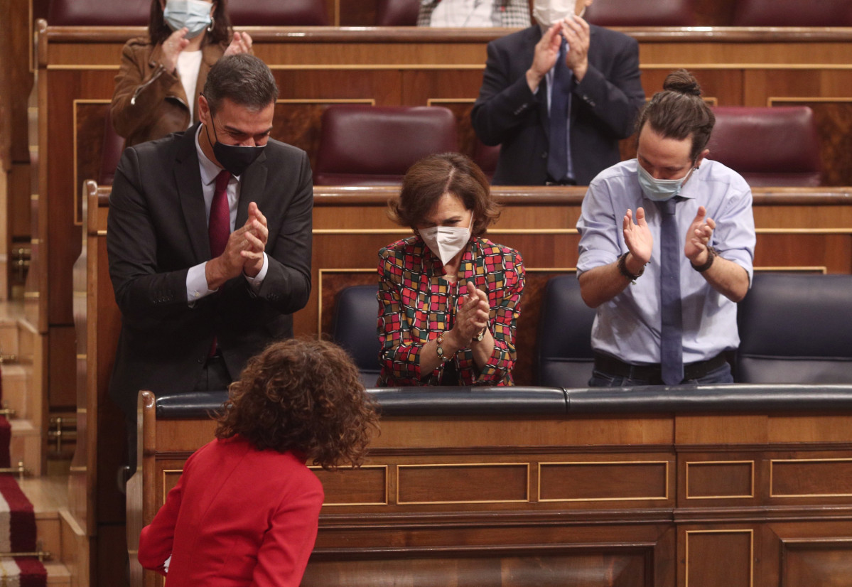 (I-D) El presidente del Gobierno, Pedro Sánchez; la vicepresidenta primera, Carmen Calvo, y el vicepresidente segundo, Pablo Iglesias, aplauden a la ministra de portavoz y de Hacienda, María Jesús 