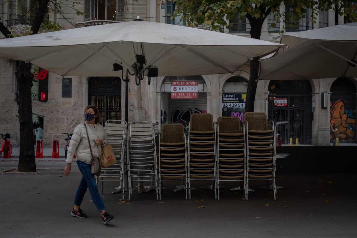 Una dona passa pel costat de la terrassa d'un bar (Arxiu)