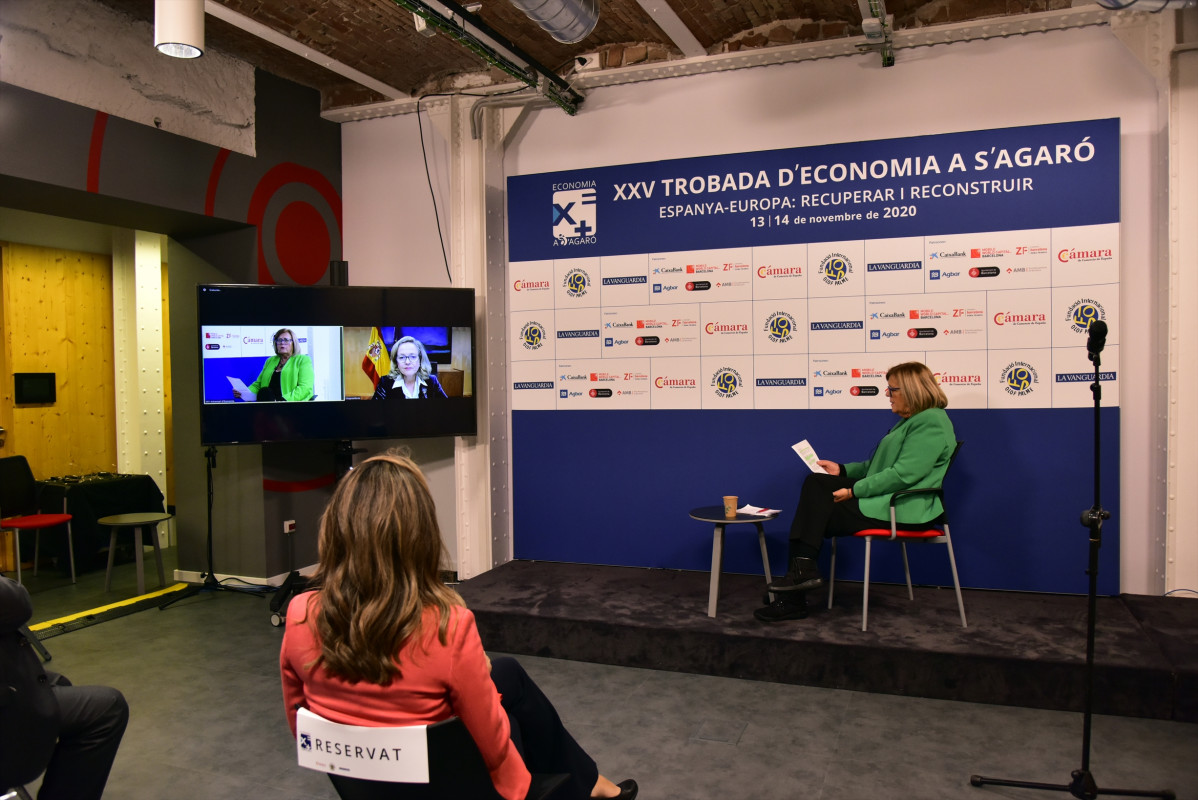 La vicepresidenta y ministra de Asuntos Económicos, Nadia Calviño (d), interviene por videoconferencia para clausurar el XXV Encuentro de Economía, en S’Agaró, en Girona, Catalunya, (España), a