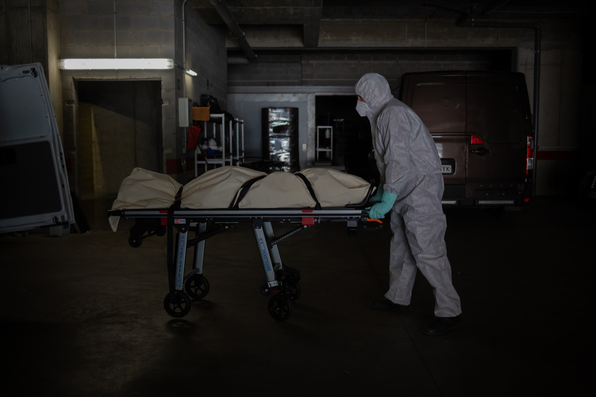 Varios operarios protegidos de los Servicios Funerarios Memora trasladan un cuerpo de una residencia de ancianos. En Girona, Cataluña, (España), a 6 de mayo de 2020.