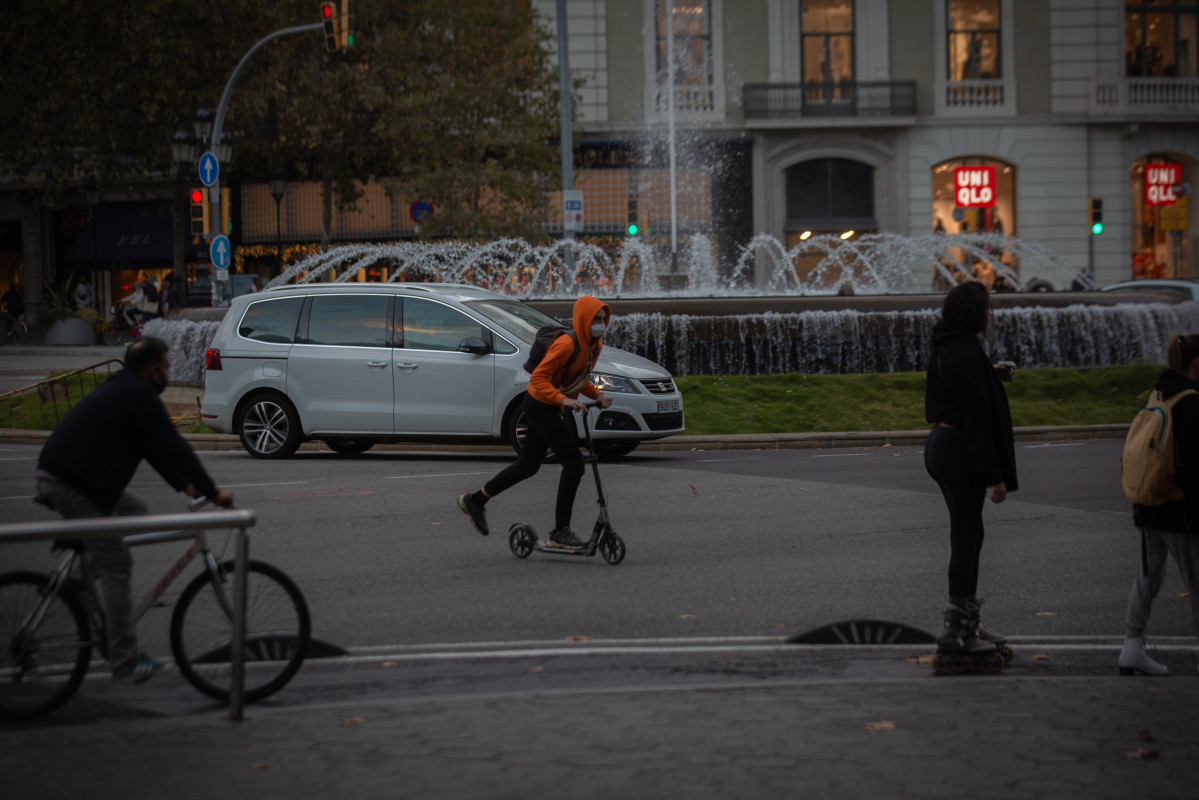 Un hombre en bici y un joven en patinete, Catalunya (España), a 10 de noviembre de 2020.   La propuesta de Plan de Movilidad Urbana (PMU) de Barcelona plantea que en 2024 un 81,52% de los desplazamientos se hagan a pie, en transporte público o en biciclet