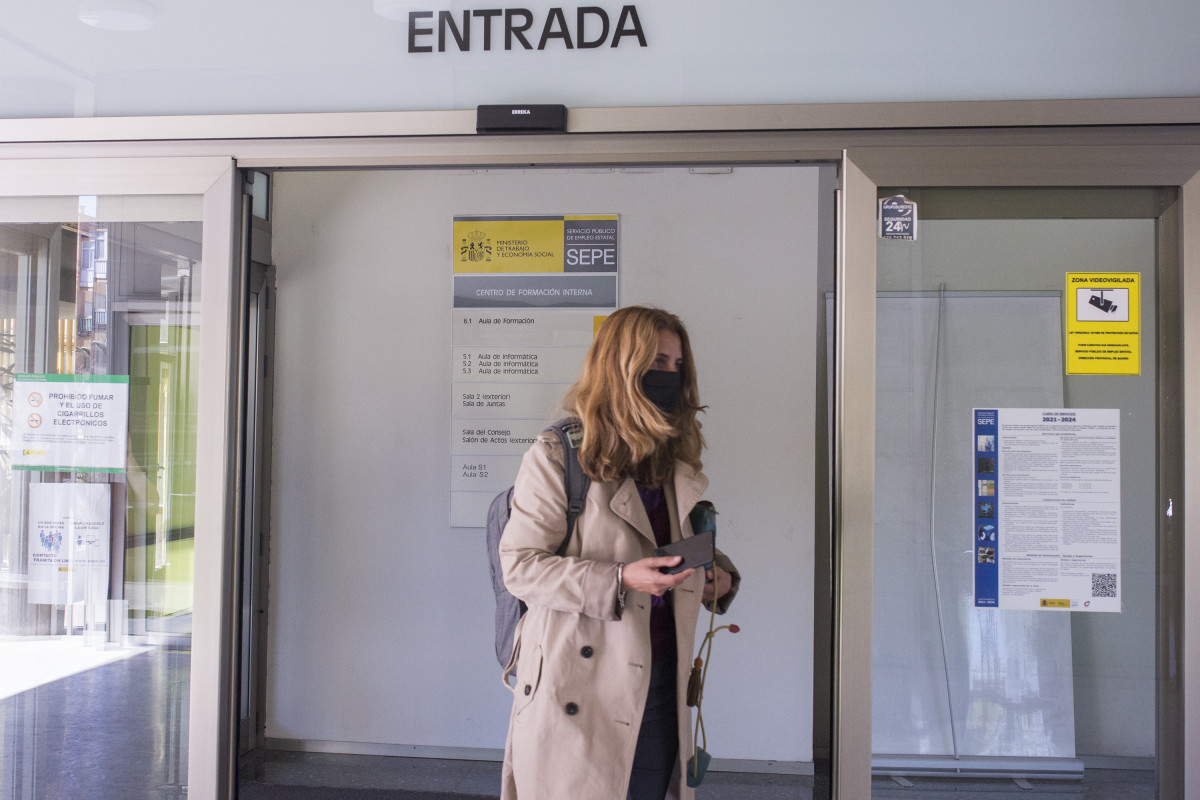 Una mujer entra por la puerta de una oficina del SEPE el día en el que se han conocido los datos de paro de marzo, a 6 de abril de 2021, en Madrid (España). El número de parados registrados en las 