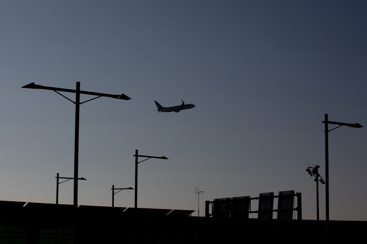 Archivo - Un avión sobrevuela el Aeropuerto de Barcelona-El Prat