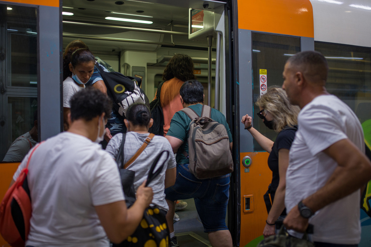 Archivo - Viajeros suben a un tren en uno de los andenes de la estación de Sants en Barcelona.