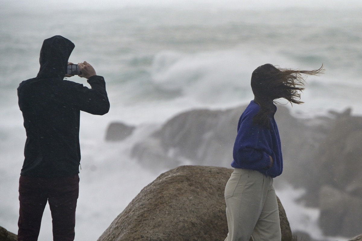 Archivo - Una persona fotografía el mar embravecido, mientras el viento mueve la melena a su acompañante, a 4 de noviembre de 2023, en A Coruña, Galicia (España).