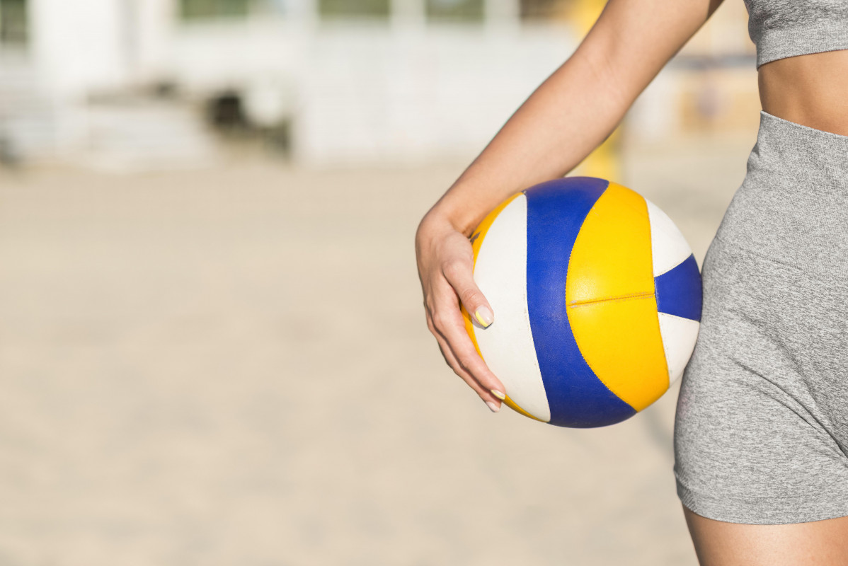 Vista frontal jugador voleibol femenino playa sosteniendo pelota espacio copia