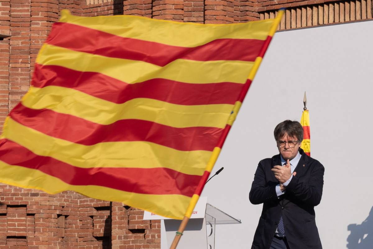 El expresidente de la Generalitat de Catalunya Carles Puigdemont aplaude durante un acto de bienvenida organizado por entidades independentistas en el paseo Lluís Companys.