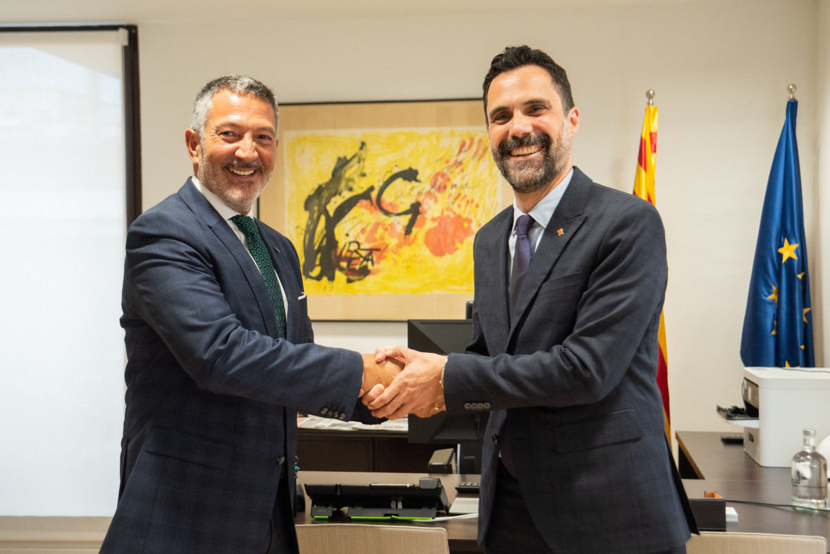 El recentment nomenat conseller d'empresa i Treball de la Generalitat, Miquel Sàmper, rep la carpeta del departament de la mà del ja exconseller Roger Torrent