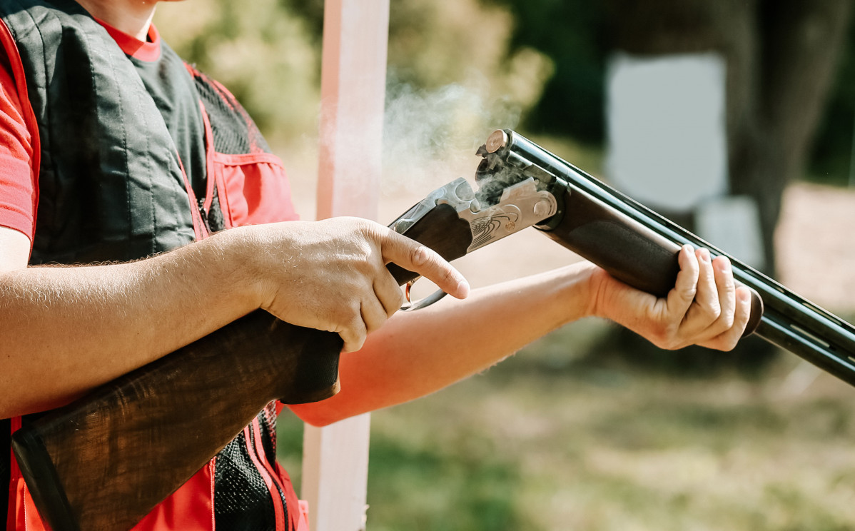 Man opens shotgun bolt after one shot with smoke