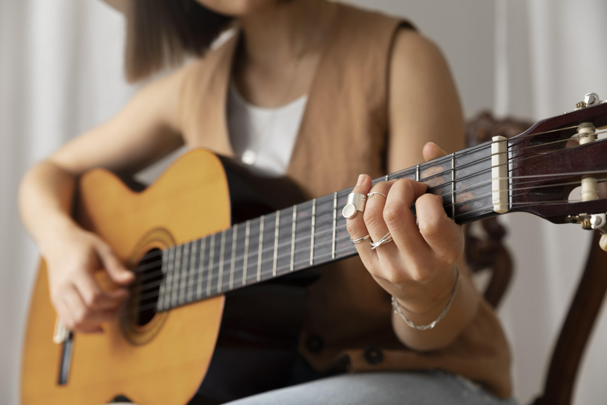 Young woman playing guitar indoors