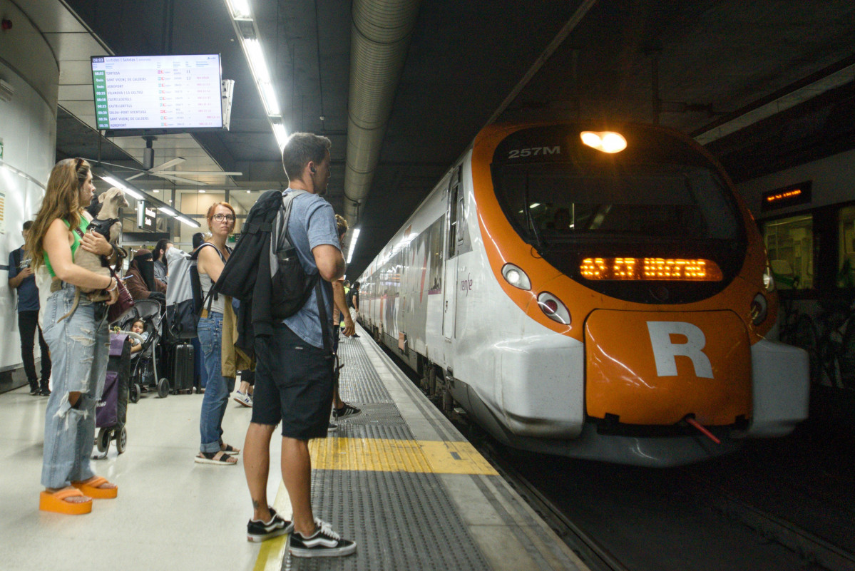 Archivo - Passatgers esperant els trens de Renfe Rodalies a Barcelona (Catalunya)