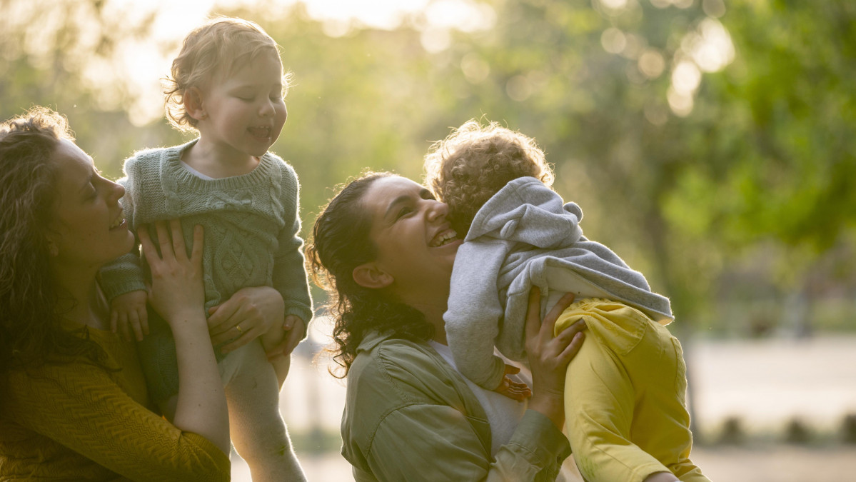 Smiley lgbt mothers outdoors park with their children