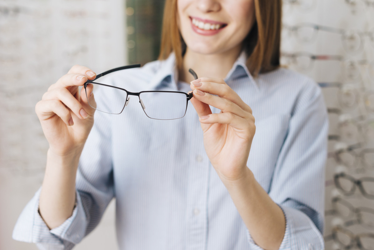 Happy woman looking new glasses optometrist