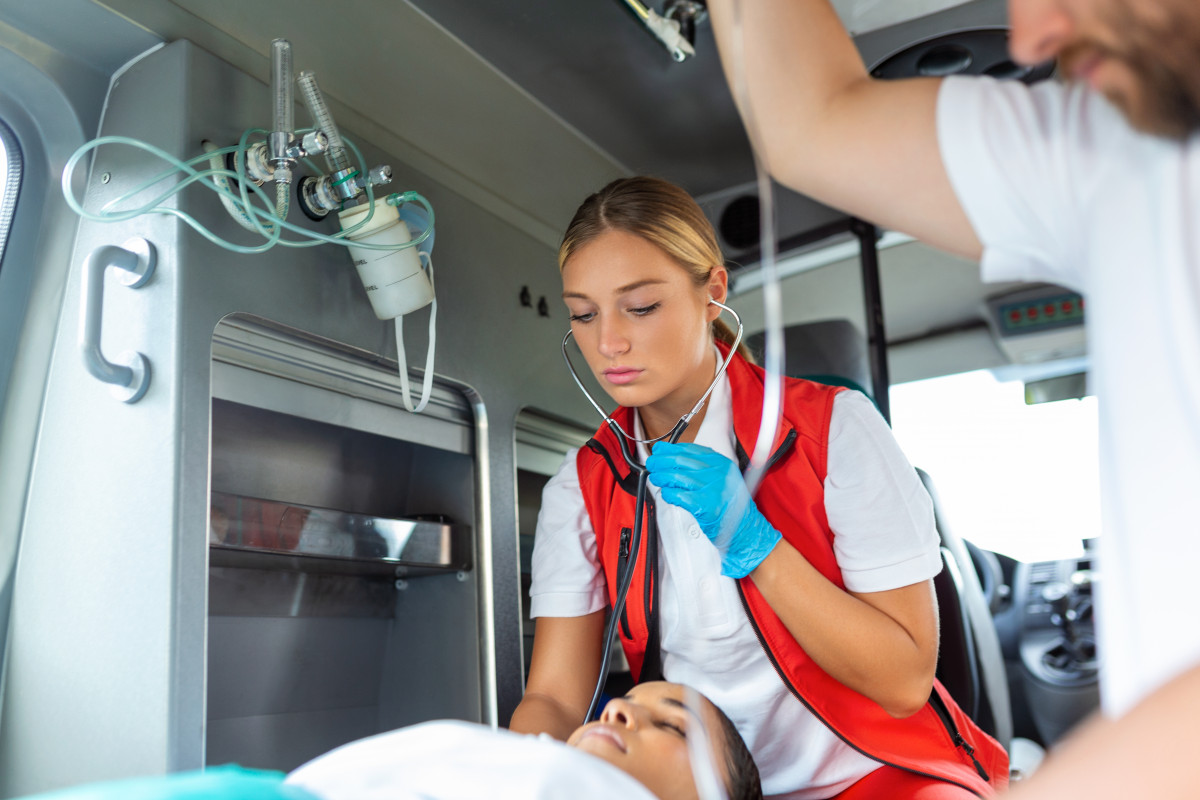 Young doctor with stetoscope listening patient heart lungs