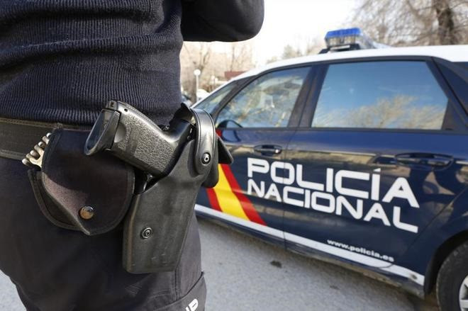 Archivo - Imagen de archivo de un agente y un coche de la Policía Nacional.