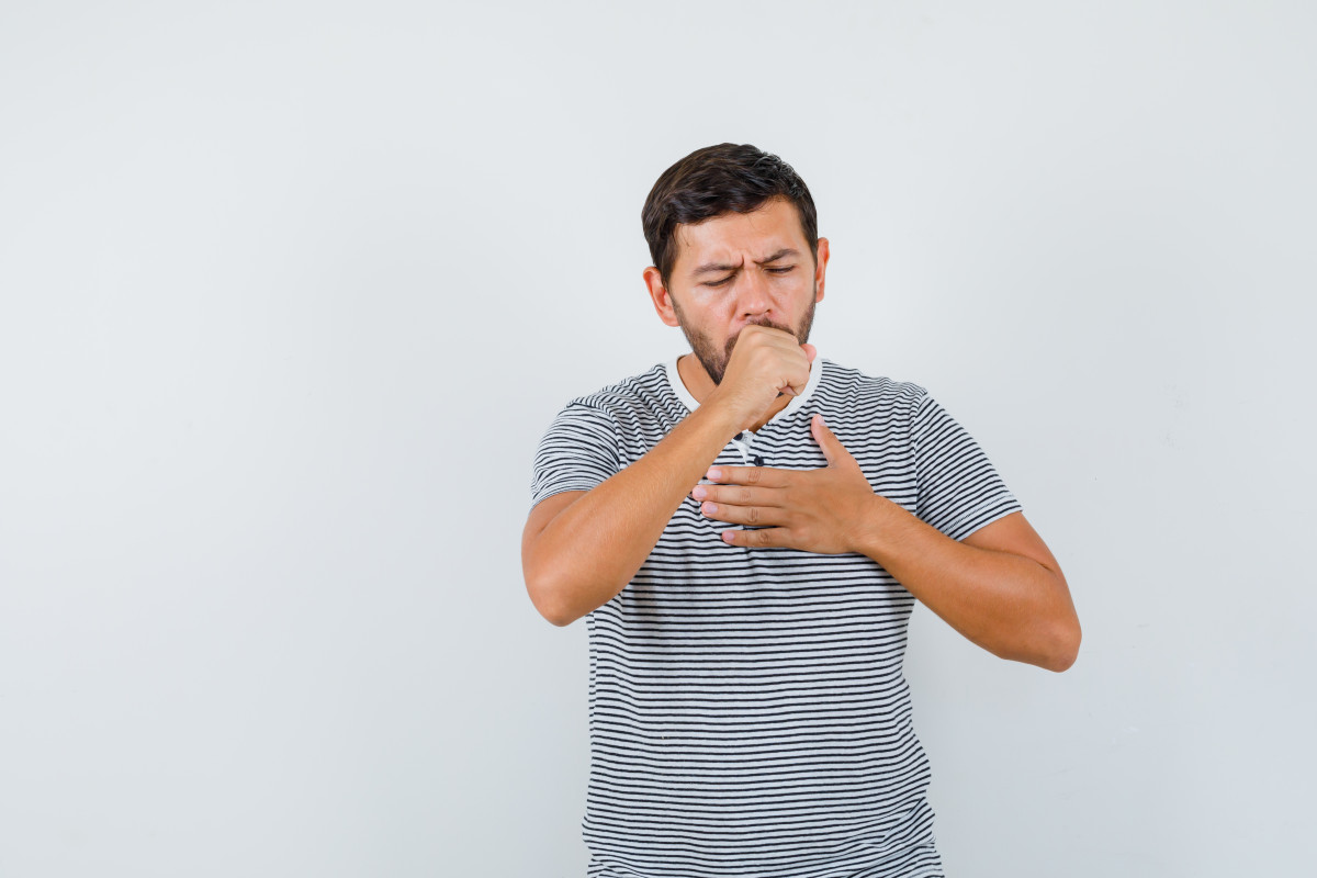 Young man suffering from cough t shirt looking sick front view