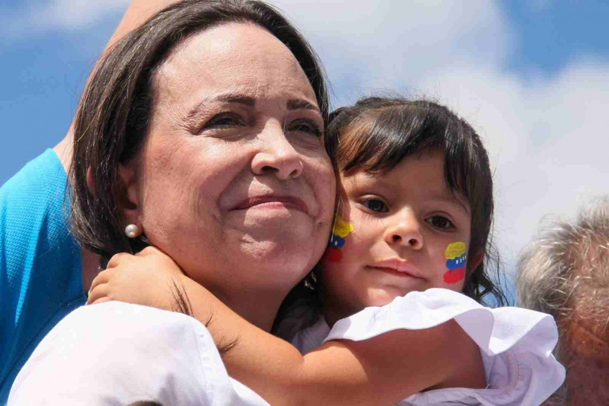 María Corina Machado es vista cargando a un niño durante su acto de campaña